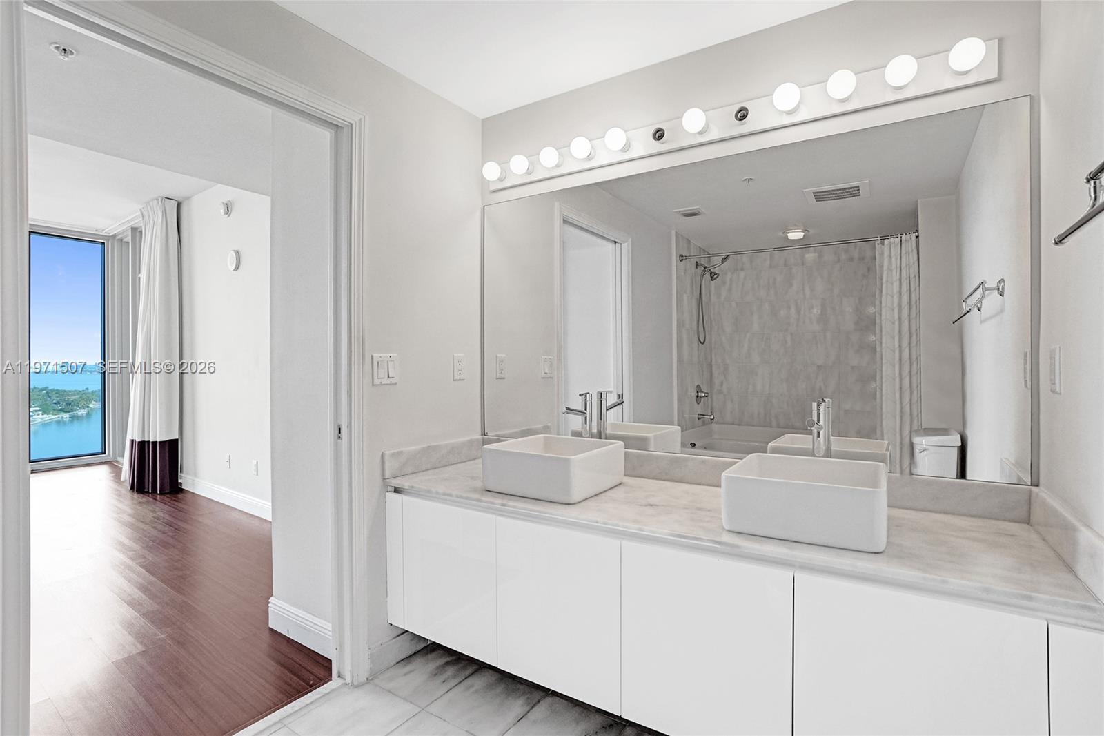 601 Northeast 36th Street, Unit 1908 Miami, FL 33137 - Photo 15 of 57 a bathroom with a sink double vanity and a mirror
