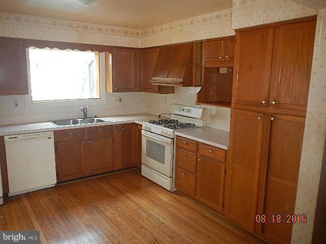12907 Holdridge Road Silver Spring, MD 20906 - Photo 8 of 14 a kitchen with wooden cabinets and white appliances