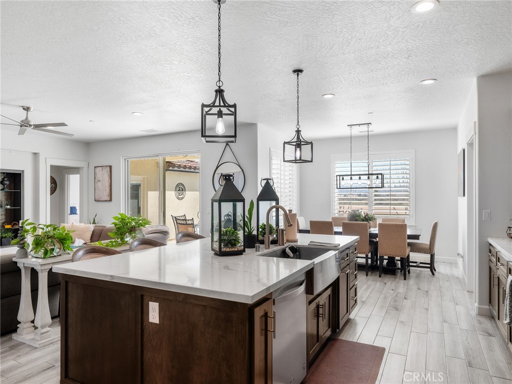 22427 Huasna Road Apple Valley, CA 92307 - Photo 12 of 39 a kitchen with stainless steel appliances kitchen island granite countertop a table chairs in it and wooden floors