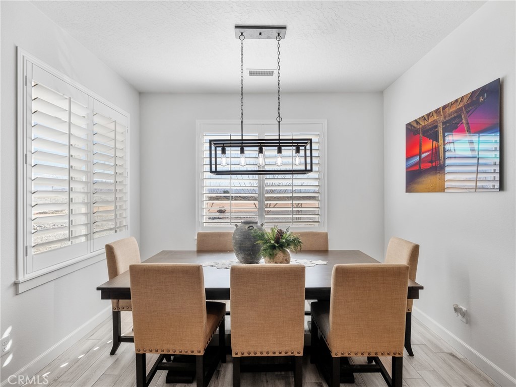 22427 Huasna Road Apple Valley, CA 92307 - Photo 13 of 39 a dining room with furniture a chandelier and window