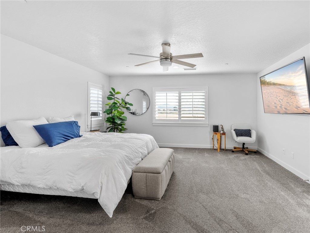 22427 Huasna Road Apple Valley, CA 92307 - Photo 17 of 39 a bedroom with a bed and a chandelier