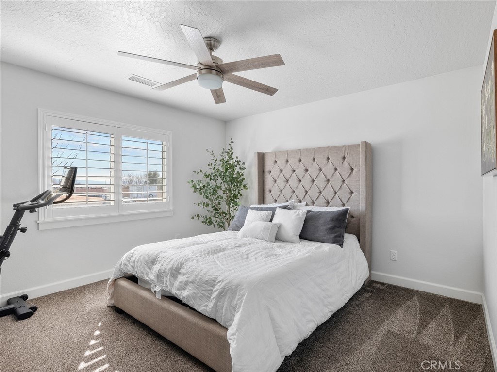 22427 Huasna Road Apple Valley, CA 92307 - Photo 23 of 39 a bedroom with a large bed and a window