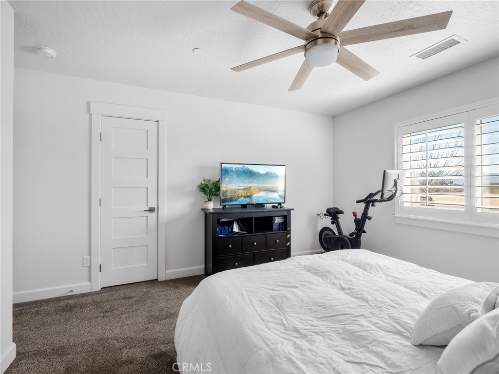 22427 Huasna Road Apple Valley, CA 92307 - Photo 24 of 39 a bedroom with a bed and a chandelier