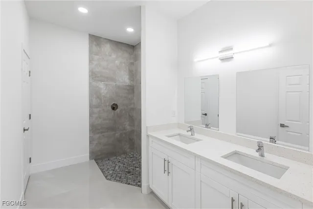 a bathroom with a double vanity sink mirror and shower