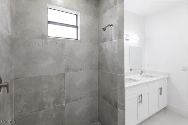 a bathroom with a granite countertop sink a shower and a mirror