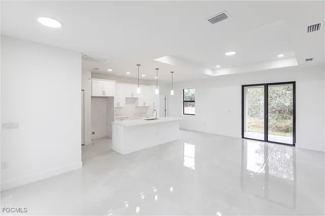 a large white kitchen with a large window
