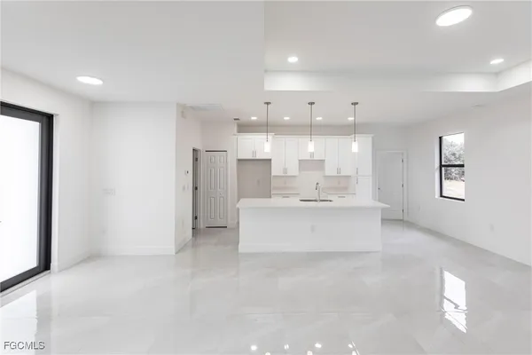 a large white kitchen with a large window