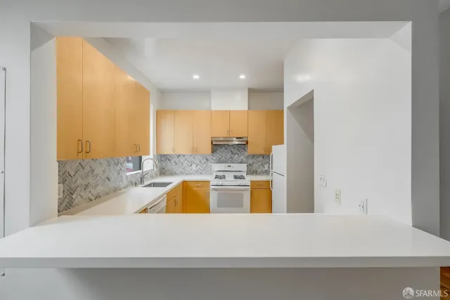 a large white kitchen with a large window