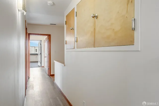 an empty room with wooden floor and windows