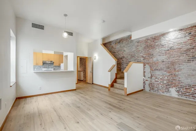 a view of a livingroom with wooden floor and a ceiling fan