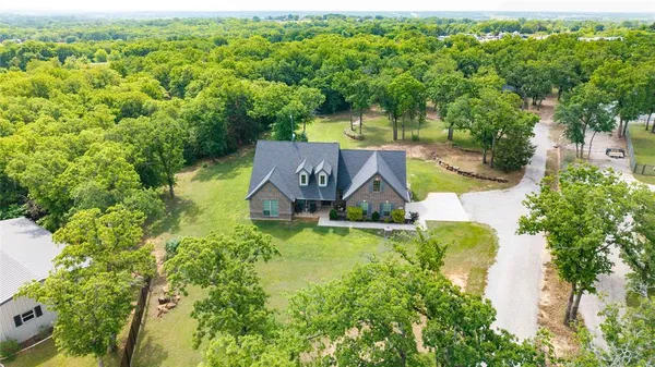 an aerial view of a house with swimming pool and garden