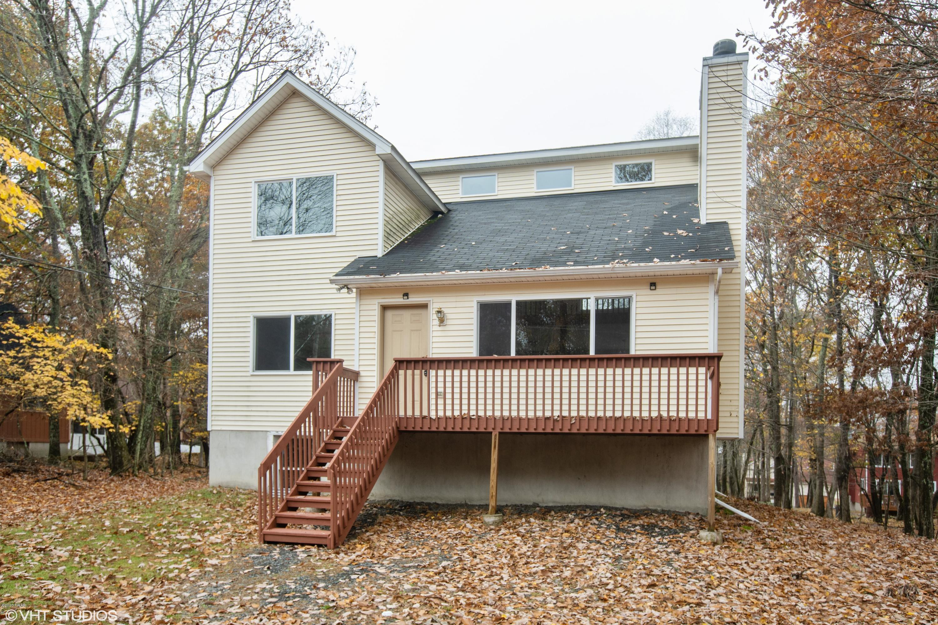 133 Roundhill Road Dingmans Ferry, PA 18328 - Photo 3 of 12 a view of a house with a bench next to a yard