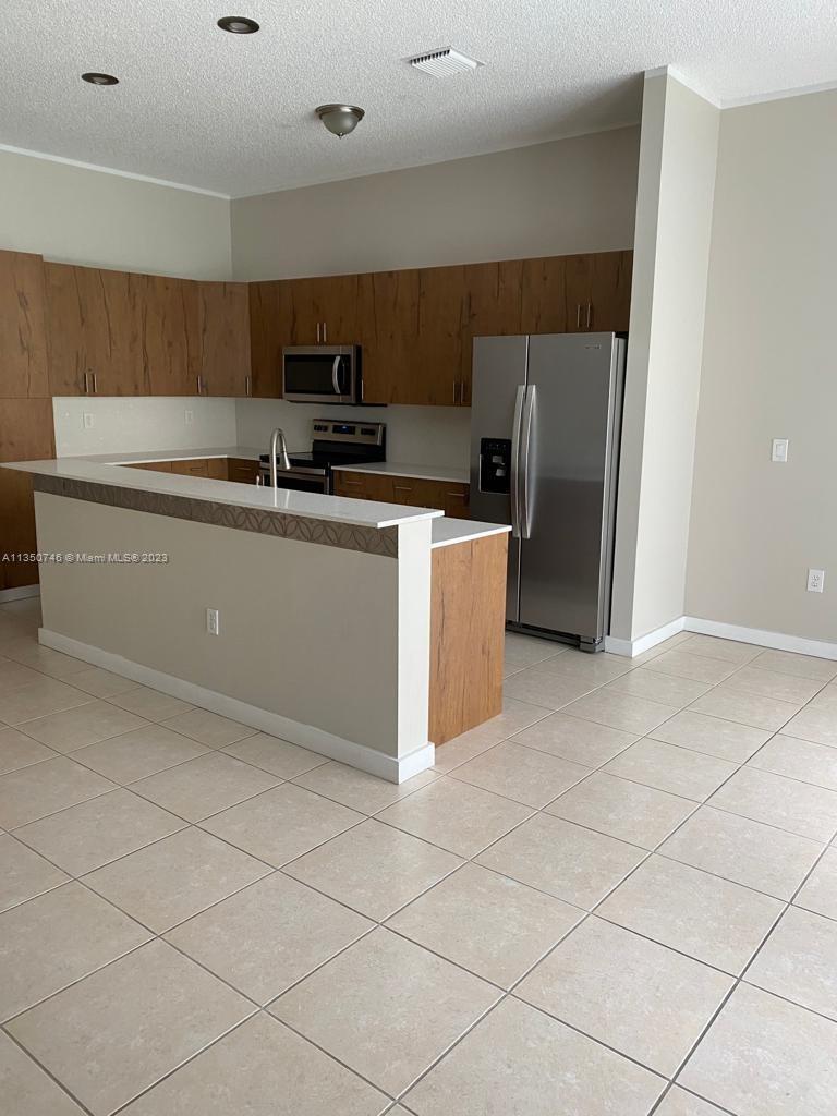 Towngate Pembroke Pines, FL 33028 - Photo 5 of 8 a kitchen with stainless steel appliances granite countertop a refrigerator and a stove top oven