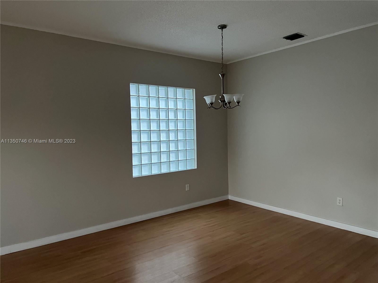 Towngate Pembroke Pines, FL 33028 - Photo 7 of 8 an empty room with wooden floor and windows