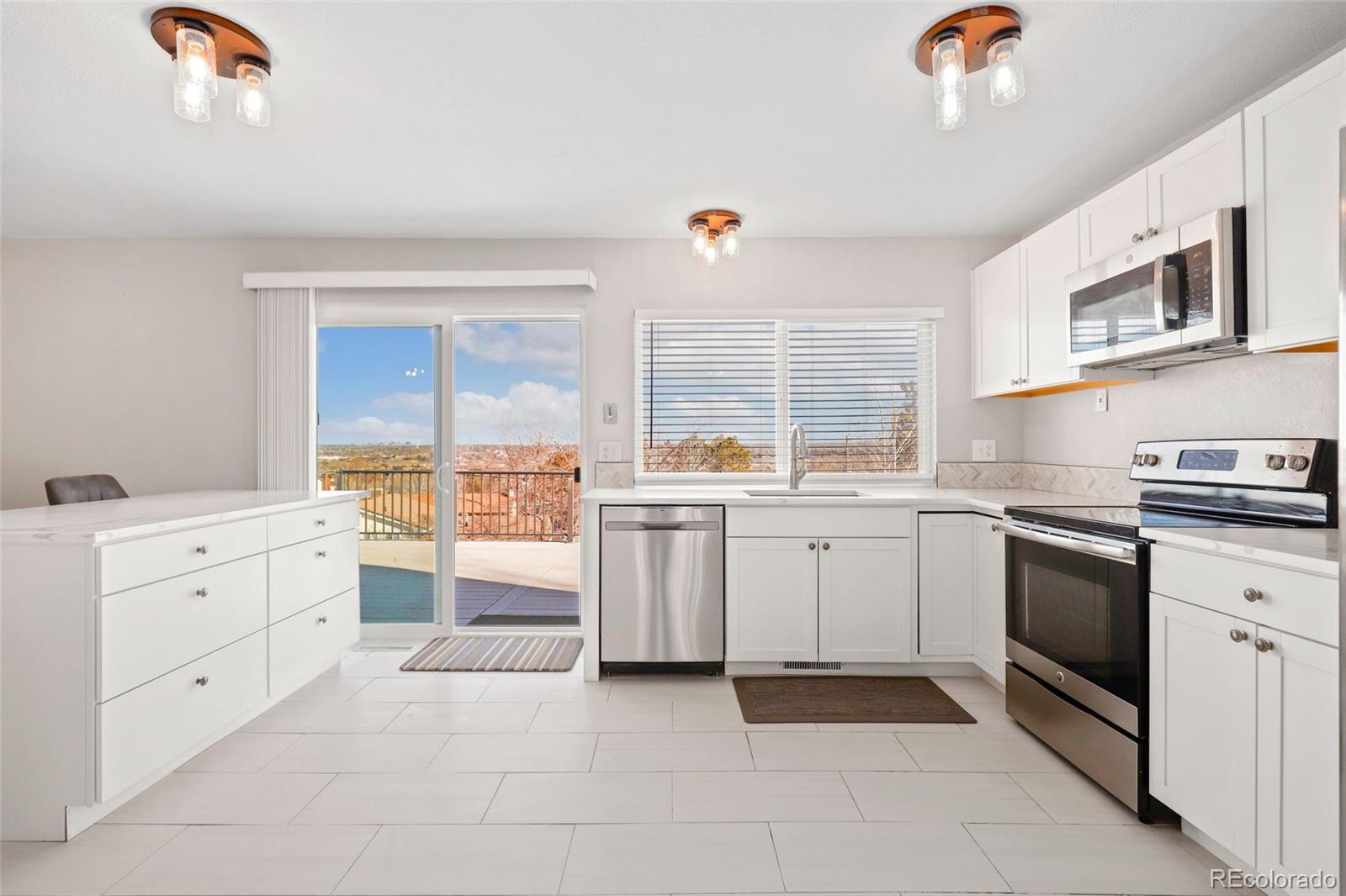 5484 South Cimarron Road Littleton, CO 80123 - Photo 12 of 40 a kitchen with white cabinets and appliances
