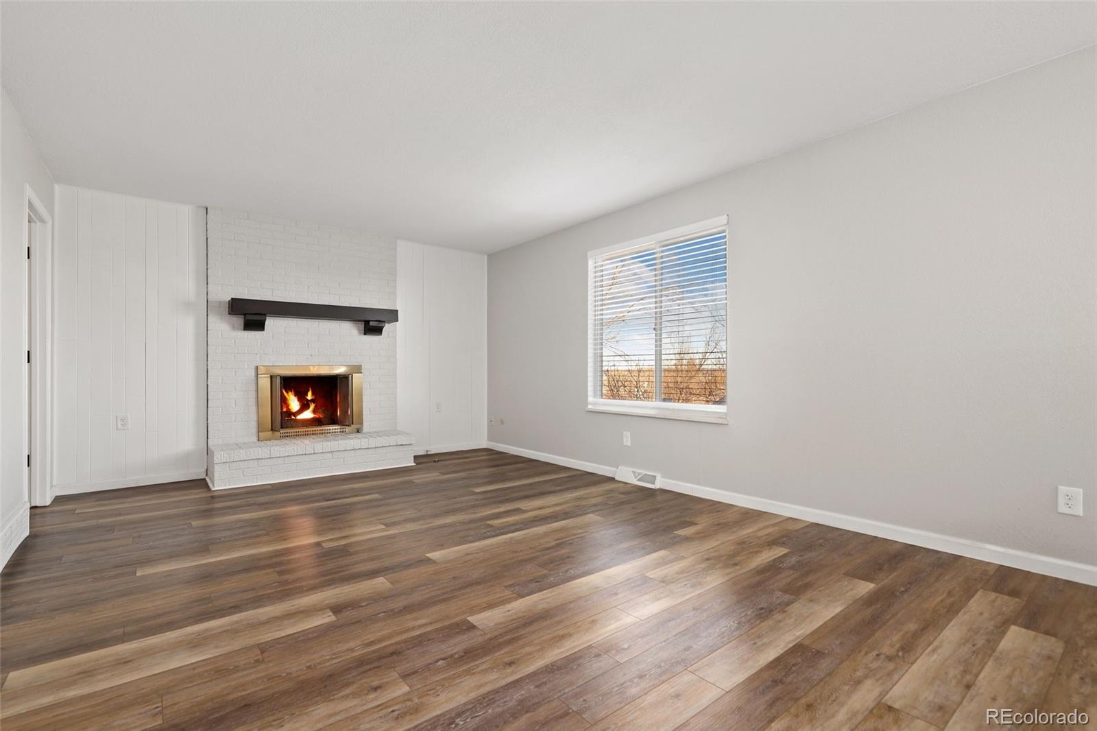 5484 South Cimarron Road Littleton, CO 80123 - Photo 18 of 40 a view of an empty room with a window and a fireplace