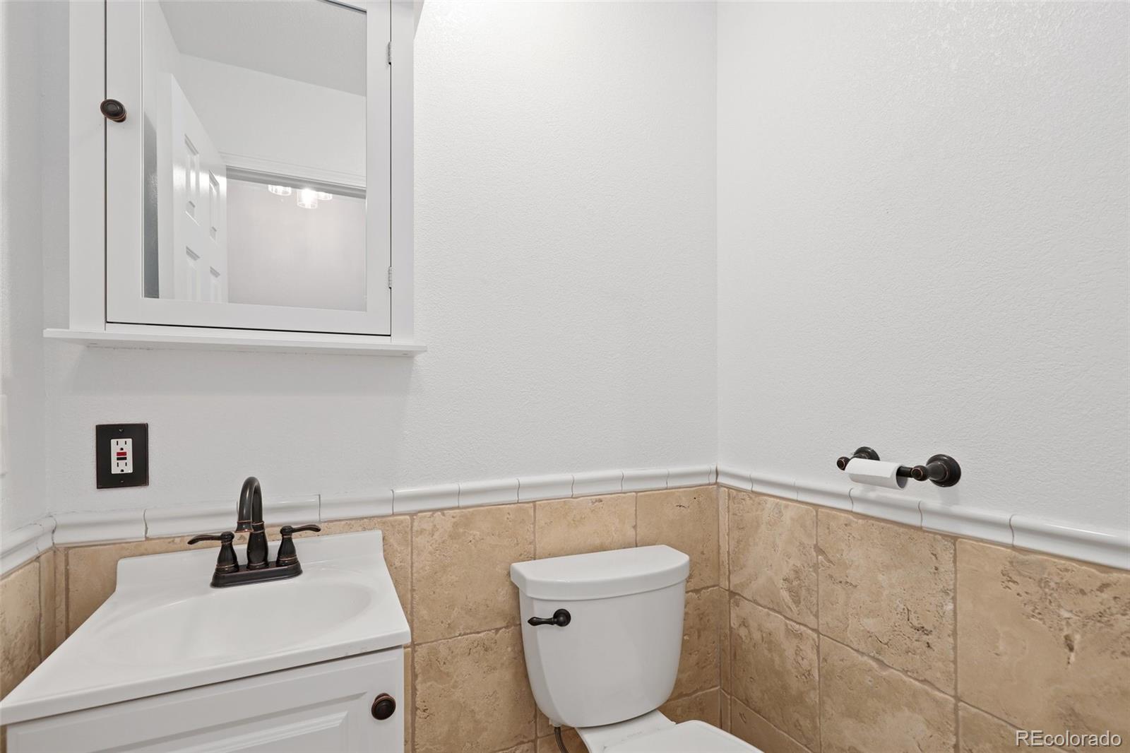 5484 South Cimarron Road Littleton, CO 80123 - Photo 21 of 40 a bathroom with a sink a toilet and a mirror