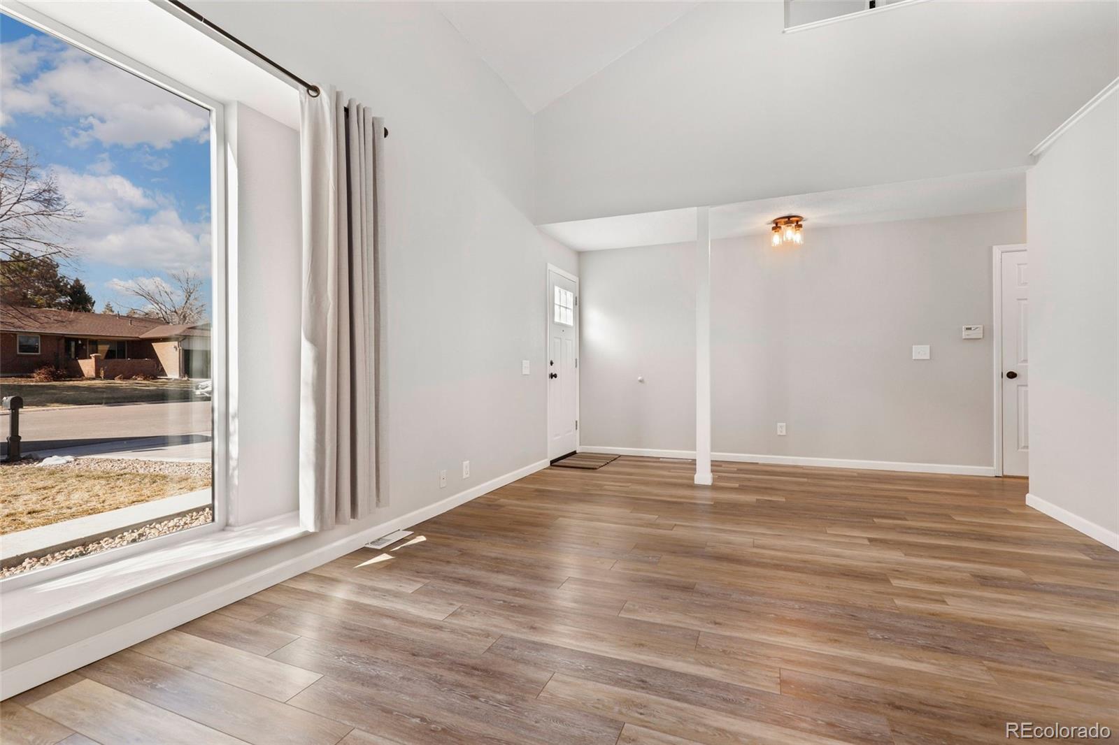 5484 South Cimarron Road Littleton, CO 80123 - Photo 9 of 40 a view of an empty room with wooden floor and a window