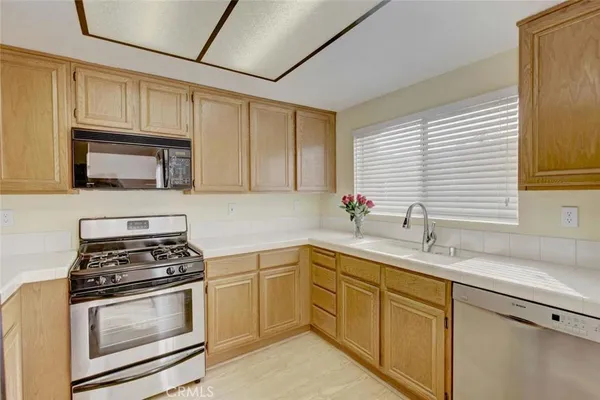 a kitchen with cabinets appliances a sink and a window