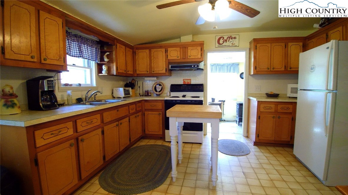 3772 Spring Valley Road Elk Creek, VA 24326 - Photo 3 of 30 a kitchen with stainless steel appliances granite countertop a sink a stove a refrigerator cabinets and chairs