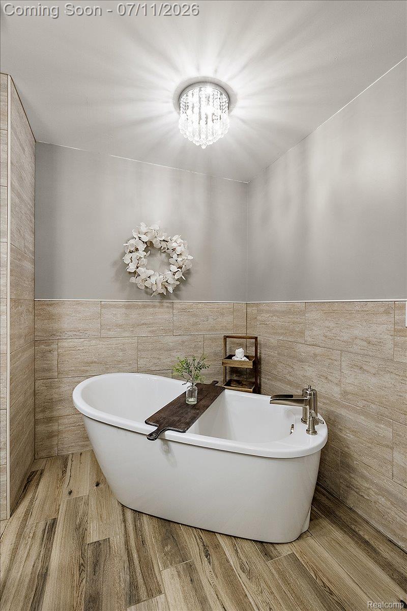 4219 Gardner Road Metamora, MI 48455 - Photo 28 of 87 Freestanding bathtub with brushed nickel fixtures, set against light wood-finish wall and floor tiling