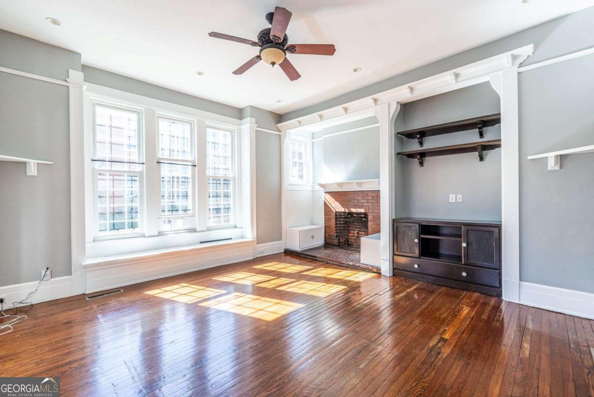 692 Myrtle Street Northeast Atlanta, GA 30308 - Photo 11 of 73 a view of a livingroom with a fireplace a ceiling fan and wooden floor