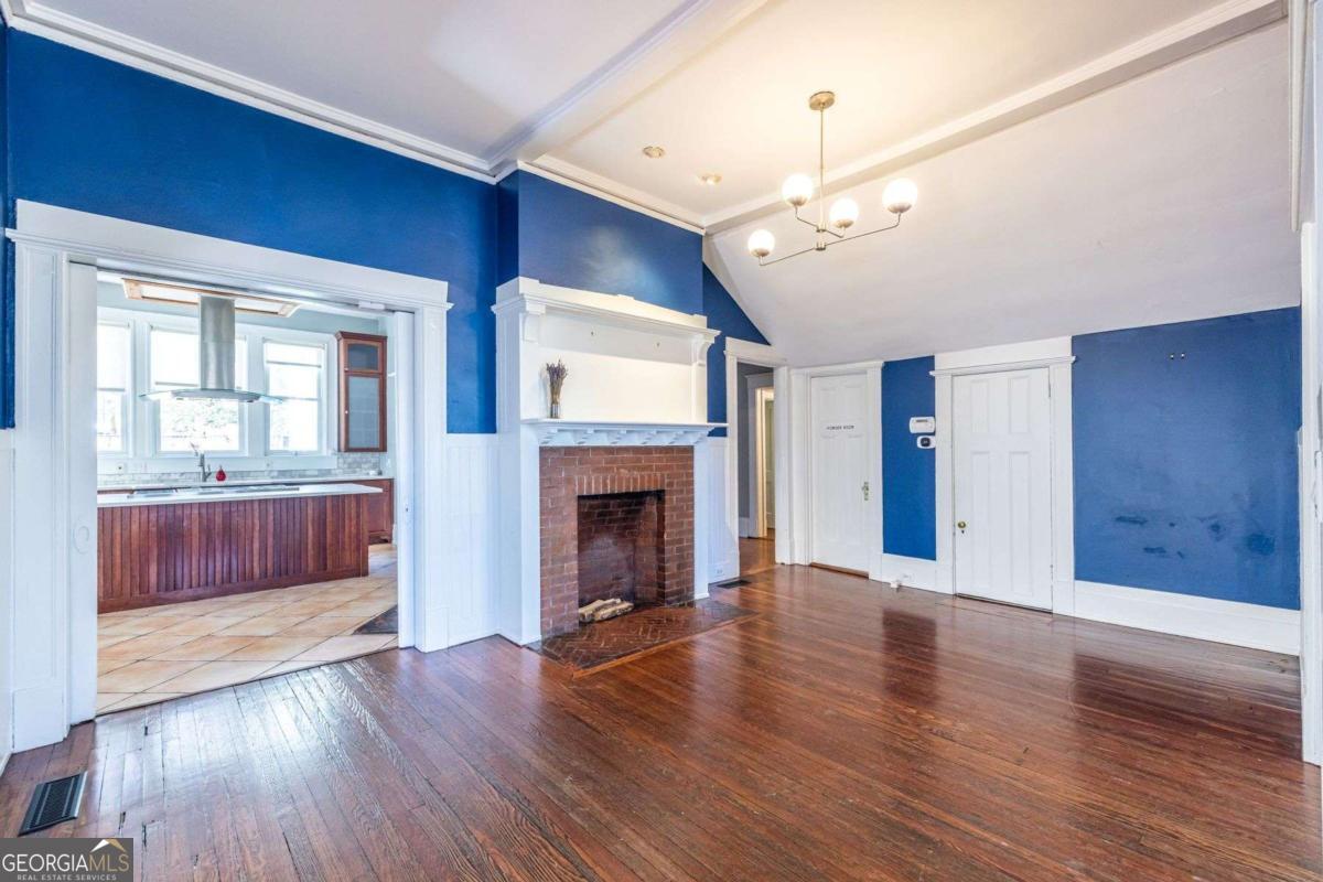 692 Myrtle Street Northeast Atlanta, GA 30308 - Photo 15 of 73 a view of a livingroom with wooden floor a fireplace a chandelier and windows