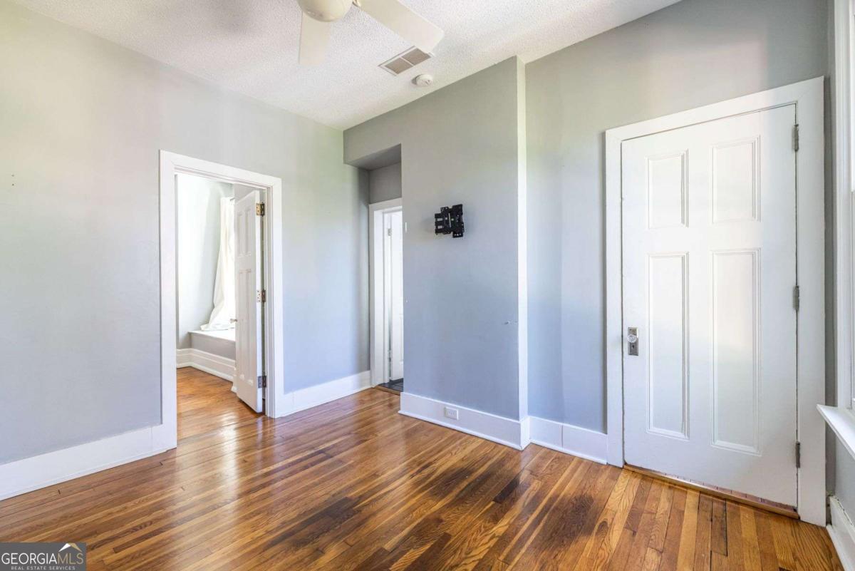 692 Myrtle Street Northeast Atlanta, GA 30308 - Photo 49 of 73 an empty room with wooden floor and a bathroom