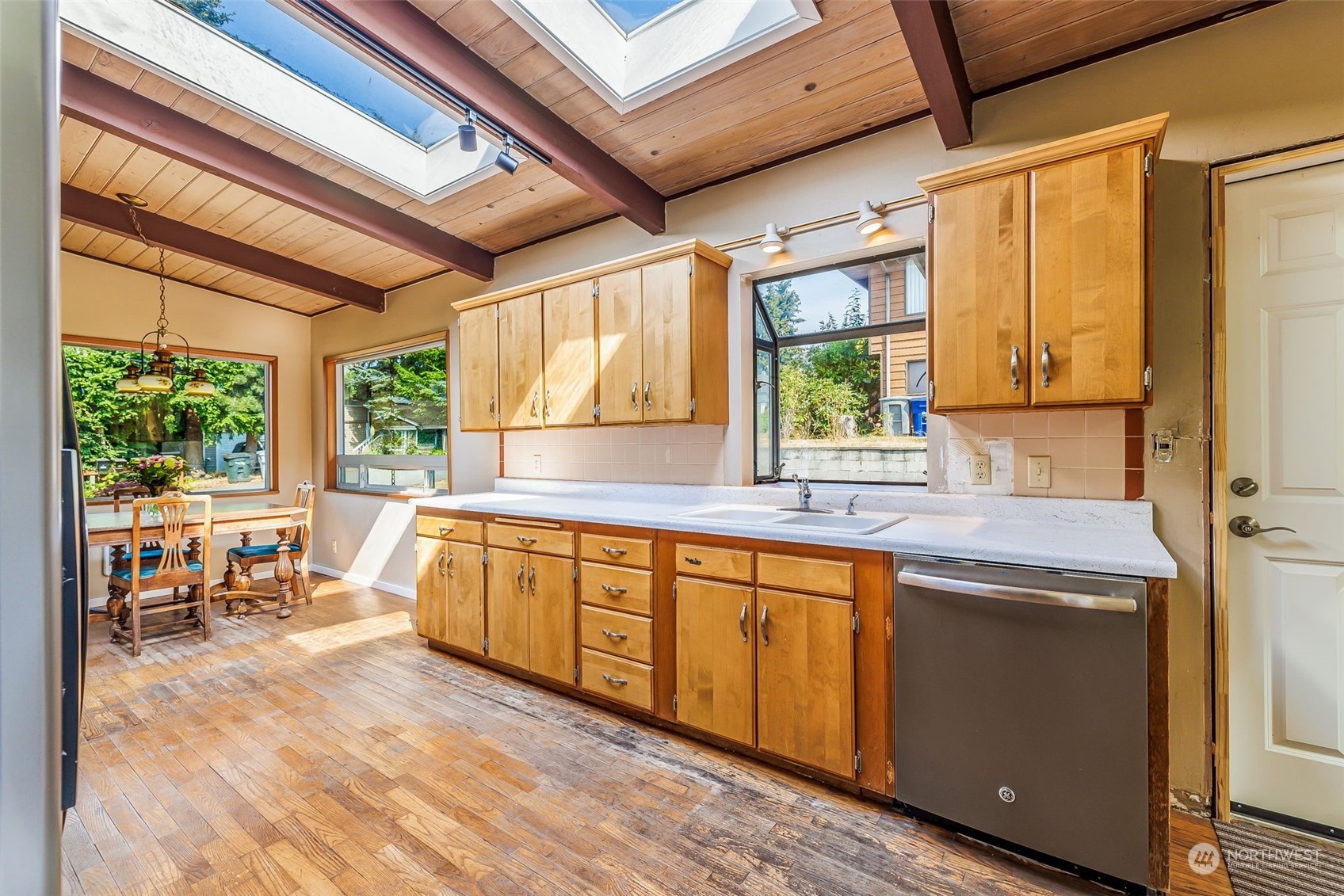 1213 North 33rd Street Renton, WA 98056 - Photo 8 of 28 a kitchen with stainless steel appliances granite countertop wooden cabinets a dining table and chairs with wooden floor