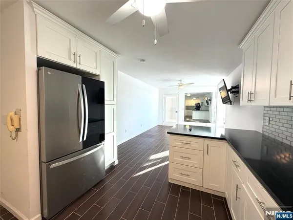 a kitchen with granite countertop a refrigerator and a sink