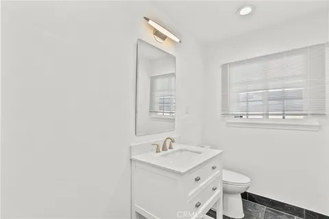 a room with stainless steel appliances kitchen island granite countertop a refrigerator and a sink