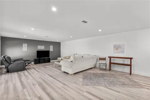 a living room with stainless steel appliances furniture a rug and a kitchen view