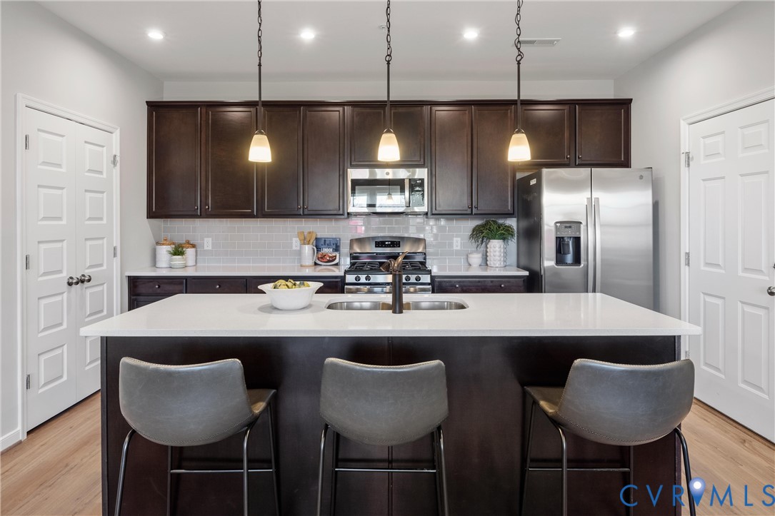 5340 Good Lndg Road, Unit 103 Glen Allen, VA 23059 - Photo 7 of 29 a kitchen with stainless steel appliances granite countertop a sink a microwave a refrigerator and chairs