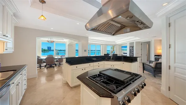 a kitchen with a stove a refrigerator and chairs