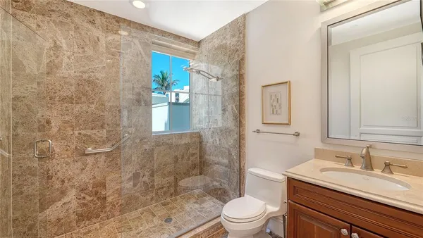 a bathroom with a granite countertop sink and a large mirror