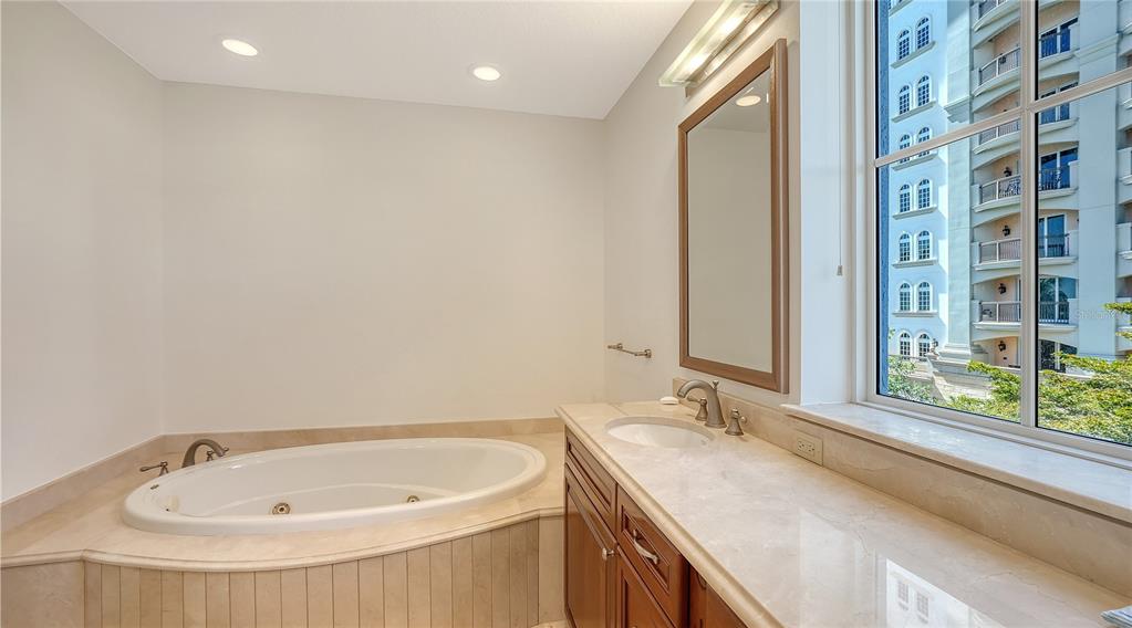 464 Golden Gate Point, Unit 304 Sarasota, FL 34236 - Photo 28 of 60 a bathroom with a granite countertop sink and a large mirror