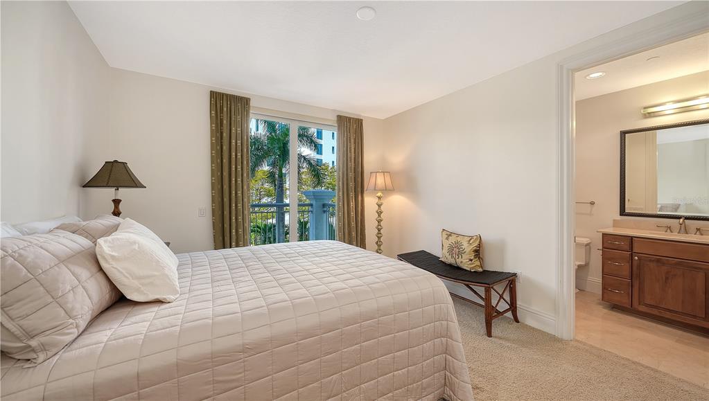464 Golden Gate Point, Unit 304 Sarasota, FL 34236 - Photo 31 of 60 a bedroom with a bed and a dresser with mirror