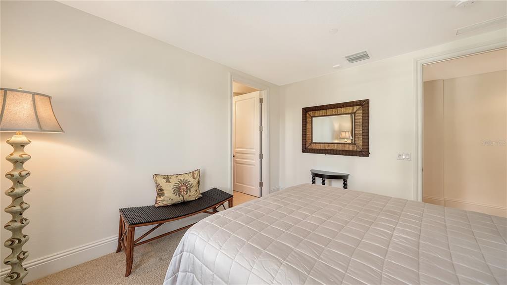464 Golden Gate Point, Unit 304 Sarasota, FL 34236 - Photo 32 of 60 a bedroom with a bed and a lamp
