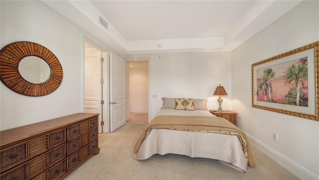464 Golden Gate Point, Unit 304 Sarasota, FL 34236 - Photo 35 of 60 a spacious bedroom with a bed and a painting on the wall