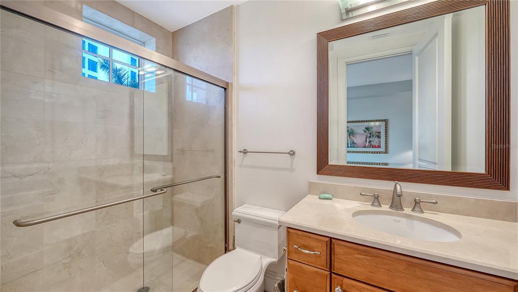 464 Golden Gate Point, Unit 304 Sarasota, FL 34236 - Photo 36 of 60 a bathroom with a granite countertop sink mirror vanity and toilet