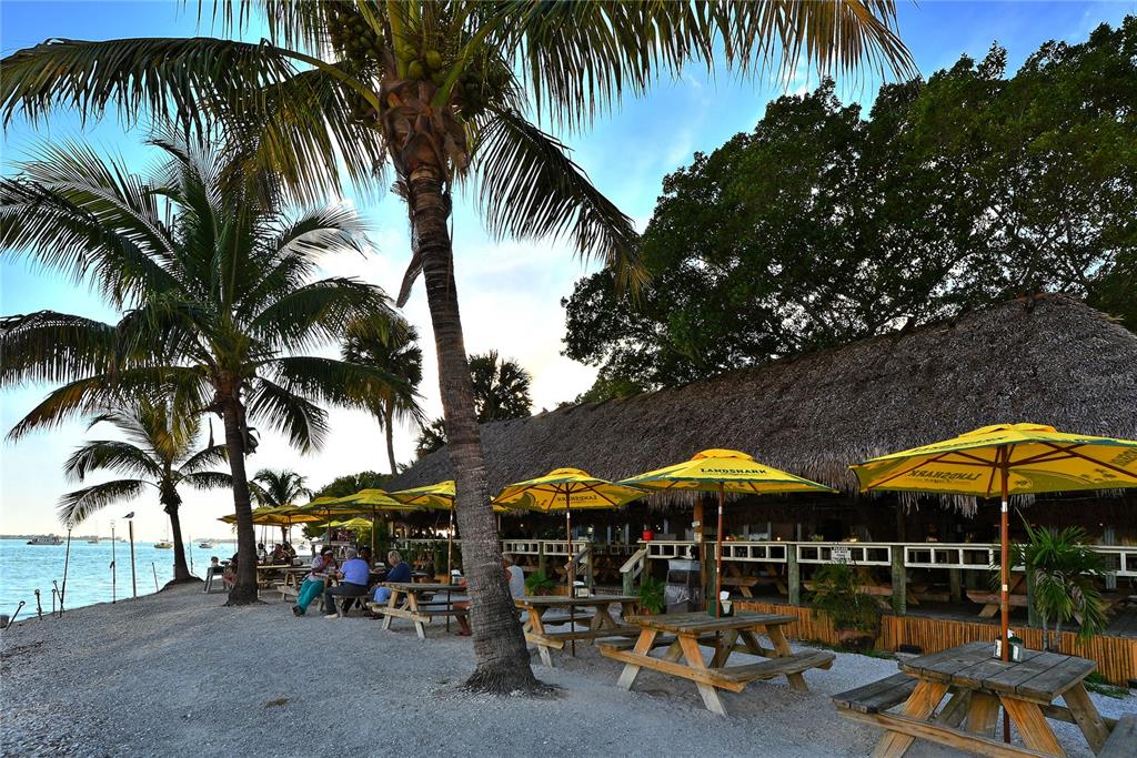 464 Golden Gate Point, Unit 304 Sarasota, FL 34236 - Photo 51 of 60 a view of a patio with swimming pool table and chairs under an umbrella