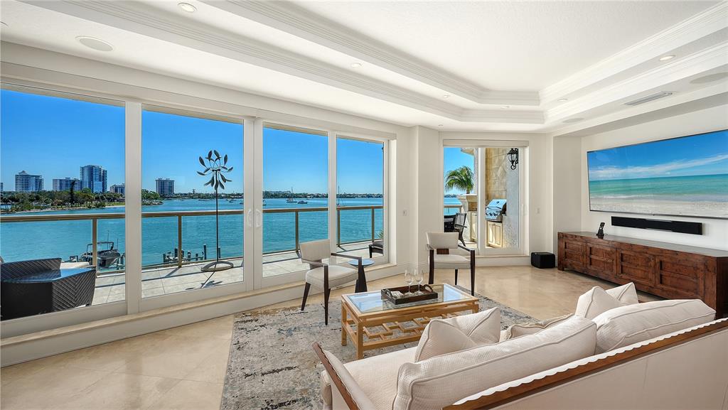 464 Golden Gate Point, Unit 304 Sarasota, FL 34236 - Photo 7 of 60 a living room with furniture large windows and a flat screen tv