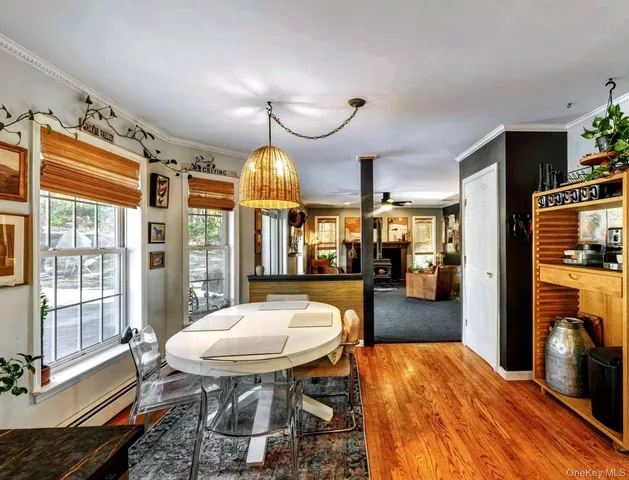 a view of a dining room with furniture a chandelier and wooden floor