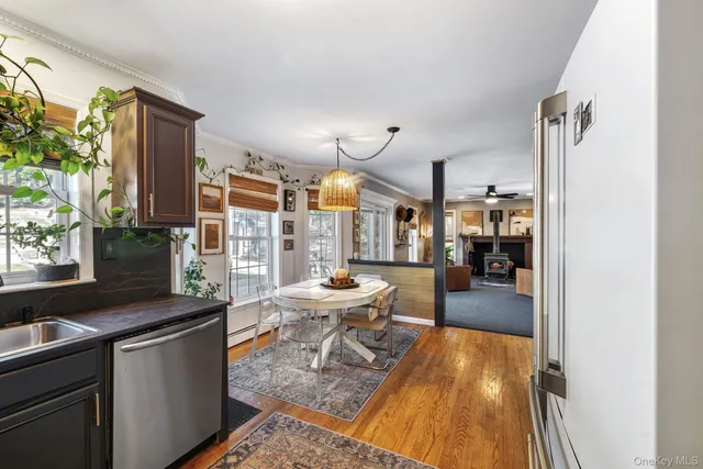 a dining room with stainless steel appliances kitchen island granite countertop a table and chairs in it