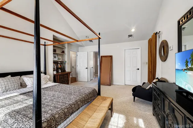 a bedroom with furniture and a large mirror