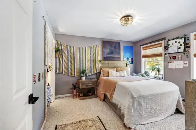 a bedroom with a bed chair and a large window