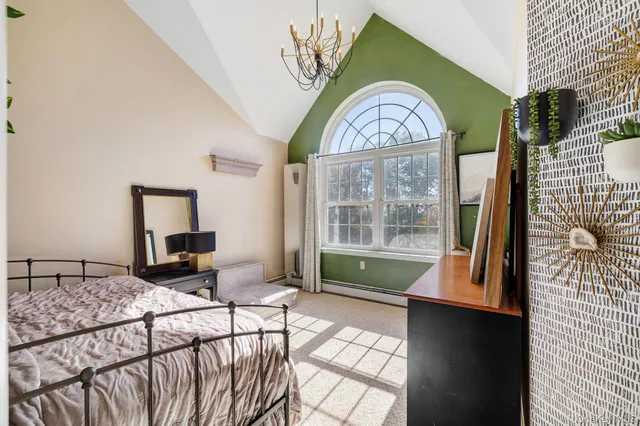 a bedroom with a bed and a painting on the wall