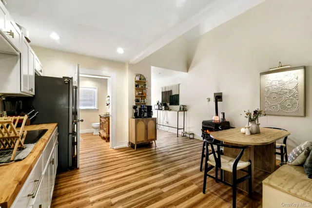 a kitchen with stainless steel appliances kitchen island granite countertop a table chairs stove and refrigerator