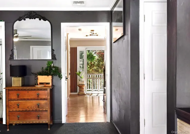 a view of a hallway with wooden floor windows and cabinet