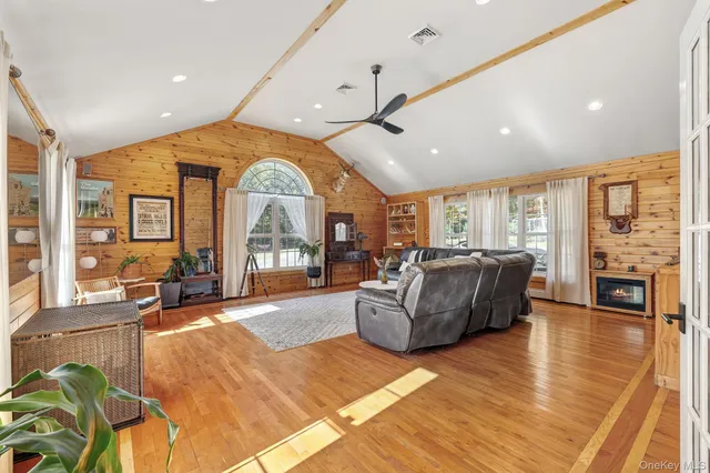 a living room with furniture large window and wooden floor